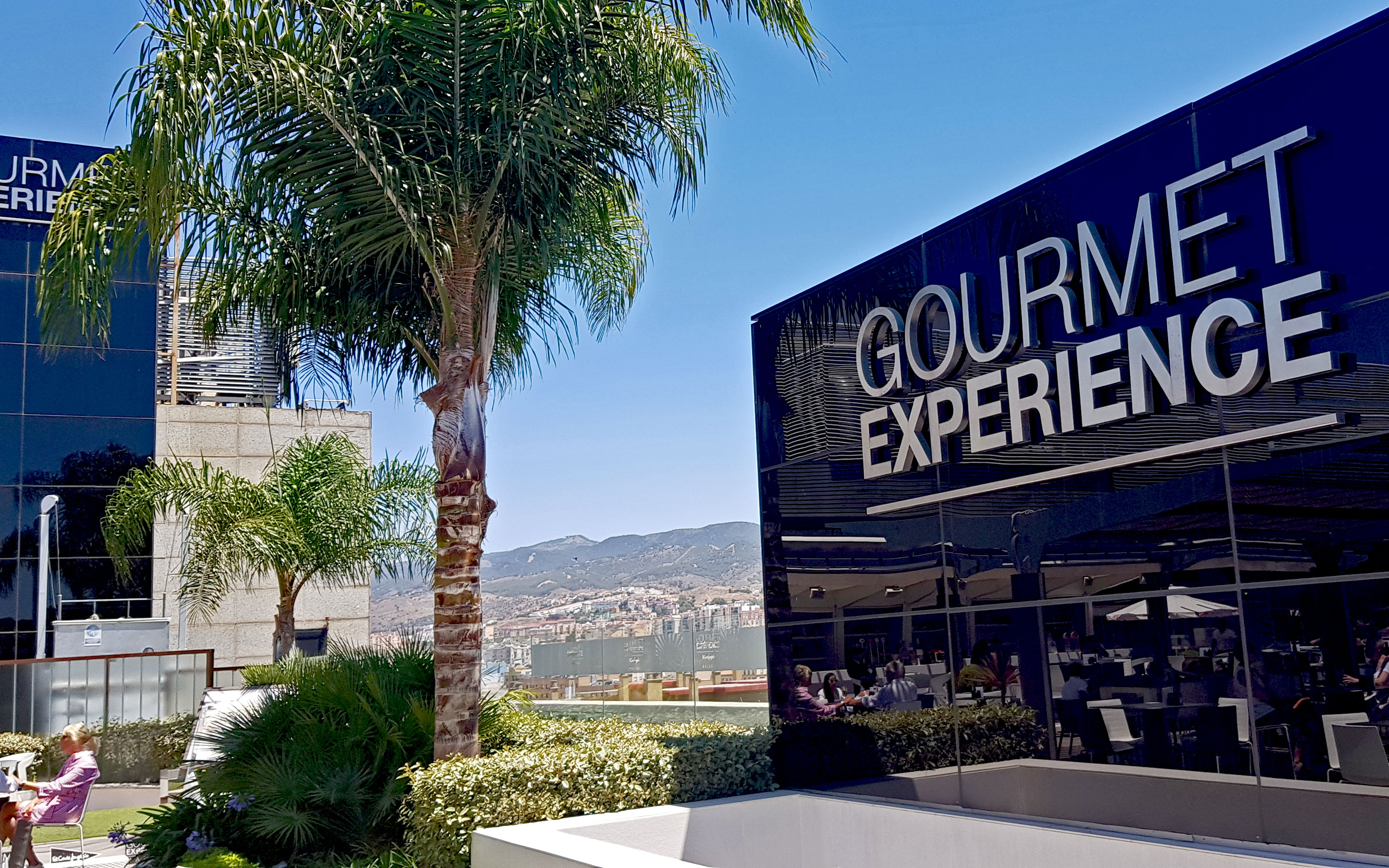 Una mujer en un café sobre la cubierta jardín