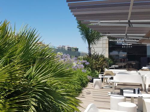 Cubierta jardín con palmeras, flores de agapanthus, mesas y sillas