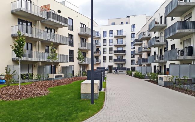 Patio de edificios residenciales con césped, árboles y pavimento